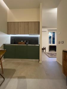 a kitchen with green cabinets and a living room at CARPE DIEM, Ponte Milvio, Olimpico, Farnesina in Rome