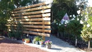 a wooden fence in a garden with potted plants at Barham Colonial Motel in Barham