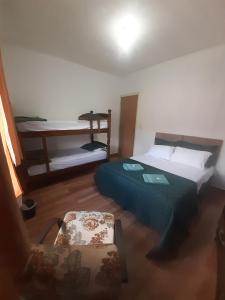 a small room with two beds and a table at Pousada Malu in Bragança Paulista