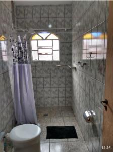 a bathroom with a toilet and a shower with a window at Pousada Malu in Bragança Paulista