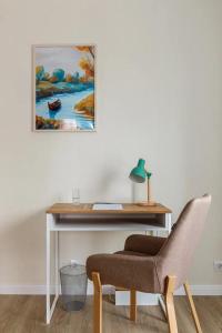 un bureau avec une chaise et un tableau mural dans l'établissement Современные Апартаменты с 2 комнатами, 