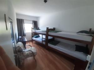 a room with two bunk beds and a chair at Pousada Malu in Bragança Paulista