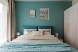 Современные Апартаменты с 2 комнатами : غرفة نوم بجدران زرقاء وسرير كبير