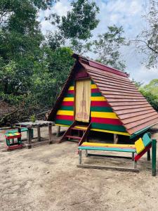 a small house with a roof on top of a bench at Land of Promise - Reggae Escape in Zanderij