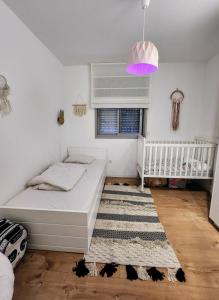 a small bedroom with a bed and a rug at דירת 6חדרים אם המושבות in Petaẖ Tiqwa