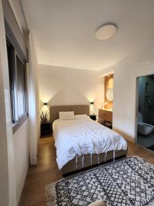 a white bedroom with a bed and a rug at דירת 6חדרים אם המושבות in Petaẖ Tiqwa