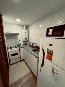 a kitchen with a white refrigerator and a stove at Departamento BELGRANO CENTRO in Paraná