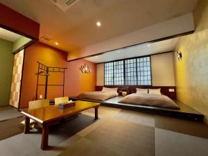 a bedroom with two beds and a table and a table sidx sidx sidx at Araha Resort Arapana in Chatan