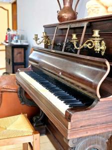 Chambres d'Hotes chez Renée في Le Charmel: يوجد بيانو قديم في الغرفة