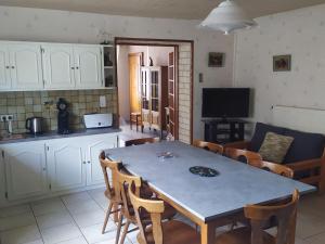 a kitchen and dining room with a table and chairs at Spacieux gîte familial avec jardin et salle de jeux, proche de Center Parcs et des Vosges - FR-1-584-45 in Repaix