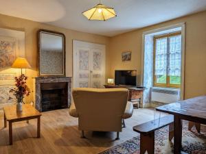 een woonkamer met een stoel en een open haard bij Charmant Gîte Indépendant au Coeur d'un Village de Campagne avec Cour Fermée - FR-1-582-222 in Saint-Didier-sur-Doulon