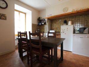 eine Küche mit einem Tisch und Stühlen sowie einem Kühlschrank in der Unterkunft Gîte Saint-Didier-sur-Doulon, 5 pièces, 8 personnes - FR-1-582-222 in Saint-Didier-sur-Doulon