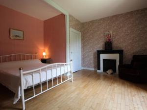 een slaapkamer met een bed en een open haard bij Charmant Gîte Indépendant au Coeur d'un Village de Campagne avec Cour Fermée - FR-1-582-222 in Saint-Didier-sur-Doulon