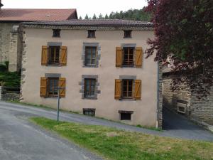een oud huis met gele luiken op een straat bij Charmant Gîte Indépendant au Coeur d'un Village de Campagne avec Cour Fermée - FR-1-582-222 in Saint-Didier-sur-Doulon