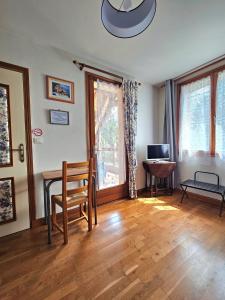 sala de estar con mesa y silla en Chambres d'Hotes chez Renée, en Le Charmel