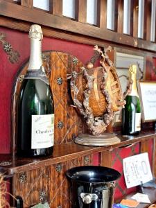 Chambres d'Hotes chez Renée في Le Charmel: زجاجة من النبيذ وقفاز البيسبول على رف