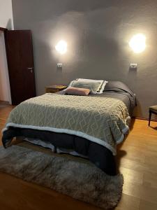 Trono de Nubes في تريفيلين: سرير في غرفة نوم مع مصباحين على الحائط