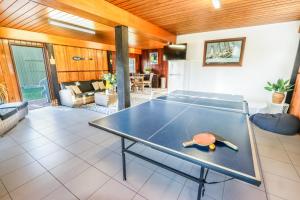 a ping pong table in a living room at A Lure - A 2-minute walk to the pristine beach! in Agnes Water
