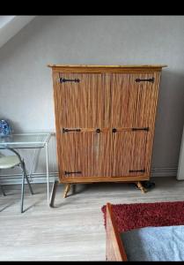 a wooden dresser in a room with a glass table at Chambre privée in Angers