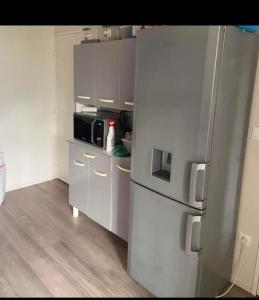 a kitchen with a refrigerator and a microwave at Chambre privée in Angers