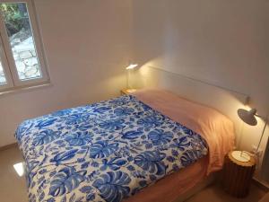 a bedroom with a bed with a blue and white blanket at Apartments by the sea Sobra, Mljet - 22329 in Babino Polje