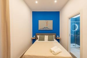 Un dormitorio con una cama con una pared azul. en R&D Scassacocchi apartments 15, en Nápoles