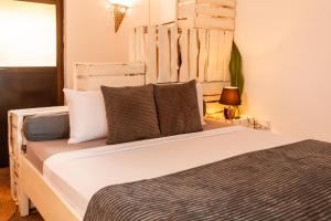um quarto com uma grande cama branca com almofadas em B4 Beach Club em Paje