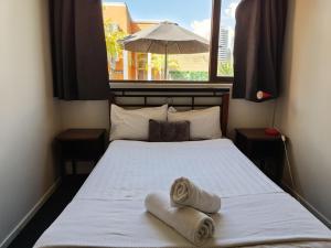 a bedroom with a bed with towels on it at City Backpackers HQ in Brisbane