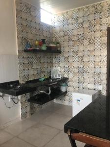 a kitchen with a black counter and a wall at Recanto do Hibisco in Prado +87 photos