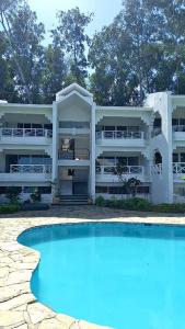 a large white apartment building with a swimming pool at tropicana sur apt221 in Sosúa