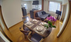 a dining table and chairs in a living room at Guest House Nishimiyanosawa in Teine