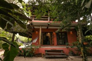 a small house with a hammock in front of it at Pousada Colmeia - Praia de Santo André, Bahia in Santo André