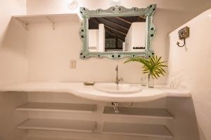 a bathroom with a sink and a mirror at Pousada Colmeia - Praia de Santo André, Bahia in Santo André