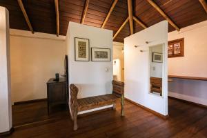 a living room with a bench and a table at Pousada Colmeia - Praia de Santo André, Bahia in Santo André