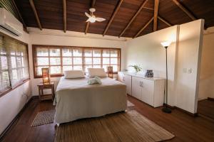 a bedroom with a bed and a ceiling fan at Pousada Colmeia - Praia de Santo André, Bahia in Santo André
