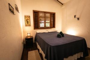 a bedroom with a bed in a room with a window at Pousada Colmeia - Praia de Santo André, Bahia in Santo André