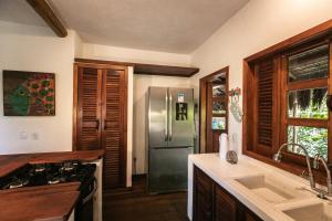a kitchen with a stainless steel refrigerator and a sink at Pousada Colmeia - Praia de Santo André, Bahia in Santo André +37 photos