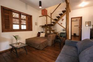 a living room with a couch and a stair case at Pousada Colmeia - Praia de Santo André, Bahia in Santo André