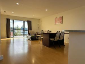 uma sala de estar com uma secretária e cadeiras num quarto em New Lynn Tidy House em Auckland