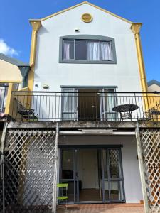 uma casa com uma varanda com uma mesa e cadeiras em New Lynn Tidy House em Auckland