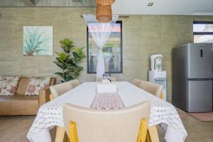 a dining room with a table with chairs and a refrigerator at ISLA VILLA 2 Luxury Pool Villa near beach with karaoke video games barbecue in Maribago