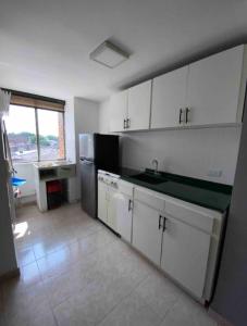 a kitchen with white cabinets and a stainless steel refrigerator at Apartamentos Sur de Cali cerca a Unicentro - 402 in Cali