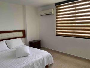 1 dormitorio con cama blanca y ventana en Apartamentos Sur de Cali cerca a Unicentro - 402 en Cali