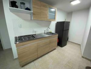 a kitchen with a stove and a refrigerator at Apartamentos Sur de Cali cerca a Unicentro - 402 in Cali