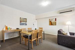 a living room with a table and chairs and a couch at Urban Apt in the Heart of Northbridge in Perth