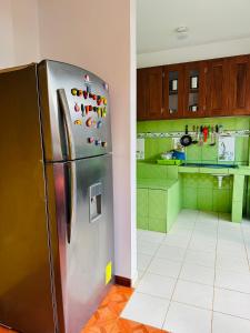 a kitchen with a stainless steel refrigerator in a room at Kayac Hostel in Huaraz