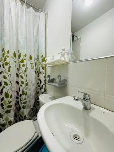 y baño con lavabo, aseo y espejo. en Kayac Hostel, en Huaraz