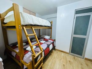 um quarto com 2 beliches e uma janela em Kayac Hostel em Huaraz