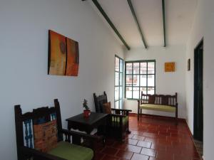 Zimmer mit Stühlen, einem Tisch und Fenstern in der Unterkunft Celeste Villa de Leyva in Villa de Leyva