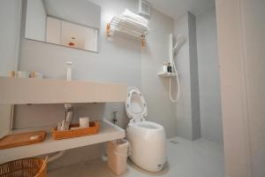 a white bathroom with a toilet and a sink at Leye Inn in Yangshuo +39 photos